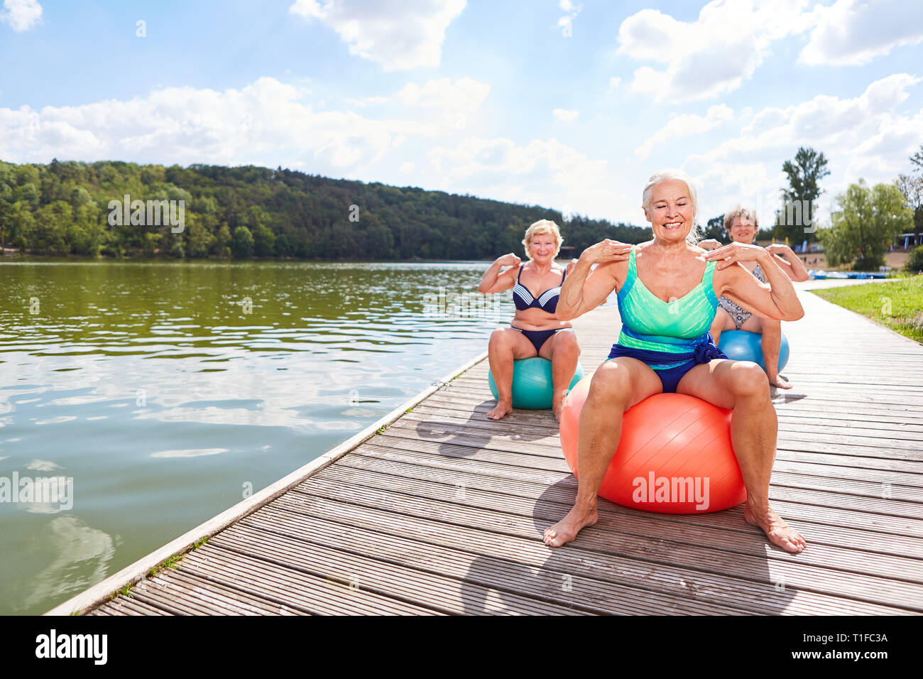 Les femmes âgées vital dans la formation de retour avec ballon de gymnastique dans le rehab sur le lac Banque D'Images