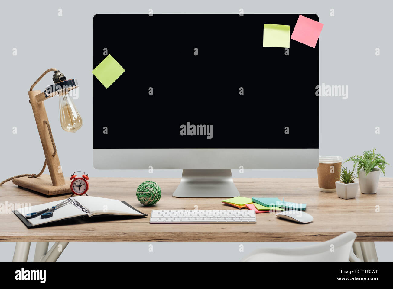 Travail moderne avec écran d'ordinateur, des notes adhésives et de papeterie au bureau en bois isolé sur gray Banque D'Images