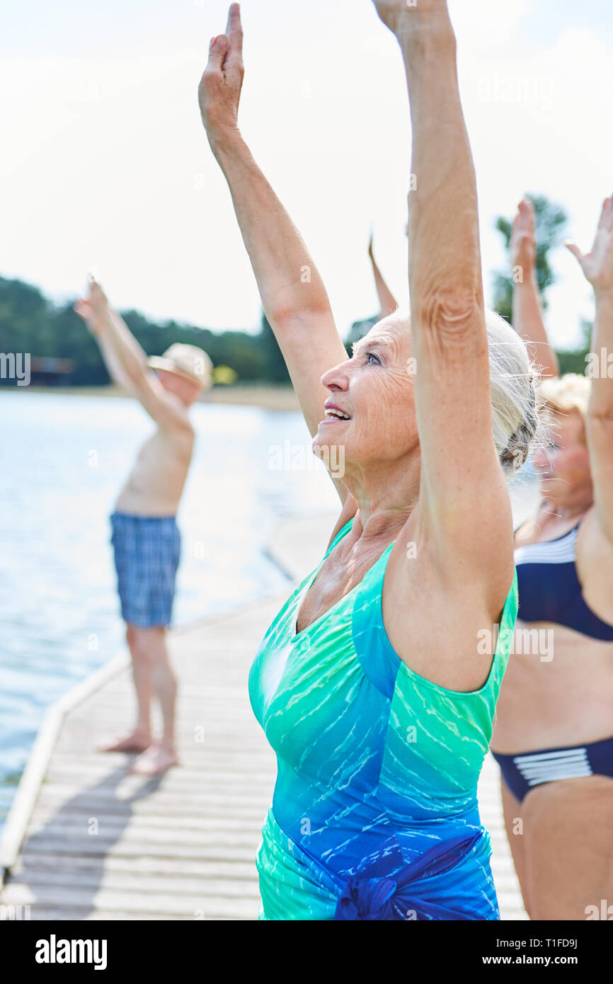 Groupe de personnes âgées qui s'étend et se réchauffer dans une salle de sport bien-être class Banque D'Images