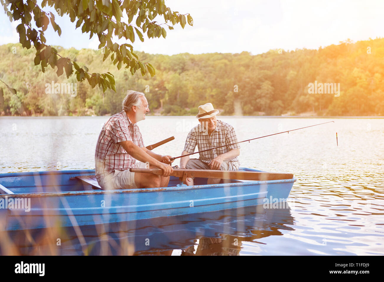 Père et fils sont de pêche ensemble dans une barque en mer en été Banque D'Images