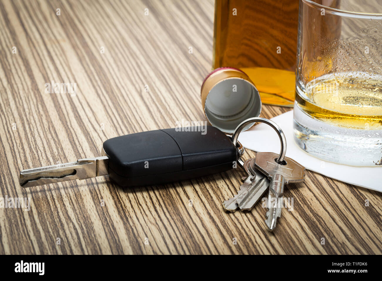 Clé de voiture sur le bar avec alcool renversé Banque D'Images