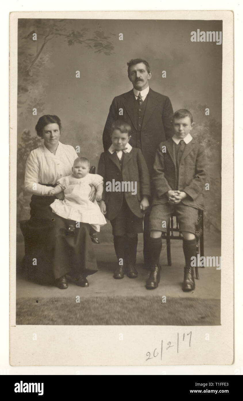 Original WW1 époque studio formel portrait de famille carte postale, enfants avec leurs parents, familles de la première Guerre mondiale. Daté du 26 février 1917, Royaume-Uni Banque D'Images