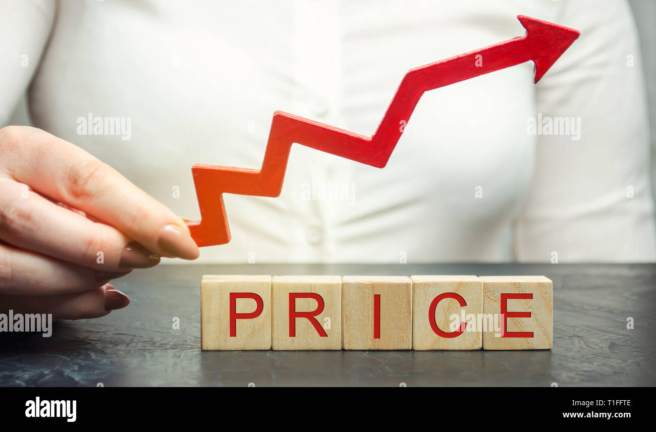 Une femme tient une flèche rouge au-dessus des blocs de bois et le prix d'inscription. La valeur de marché en croissance. L'établissement des prix. L'économie de marché. L'inflation. Pri des consommateurs Banque D'Images