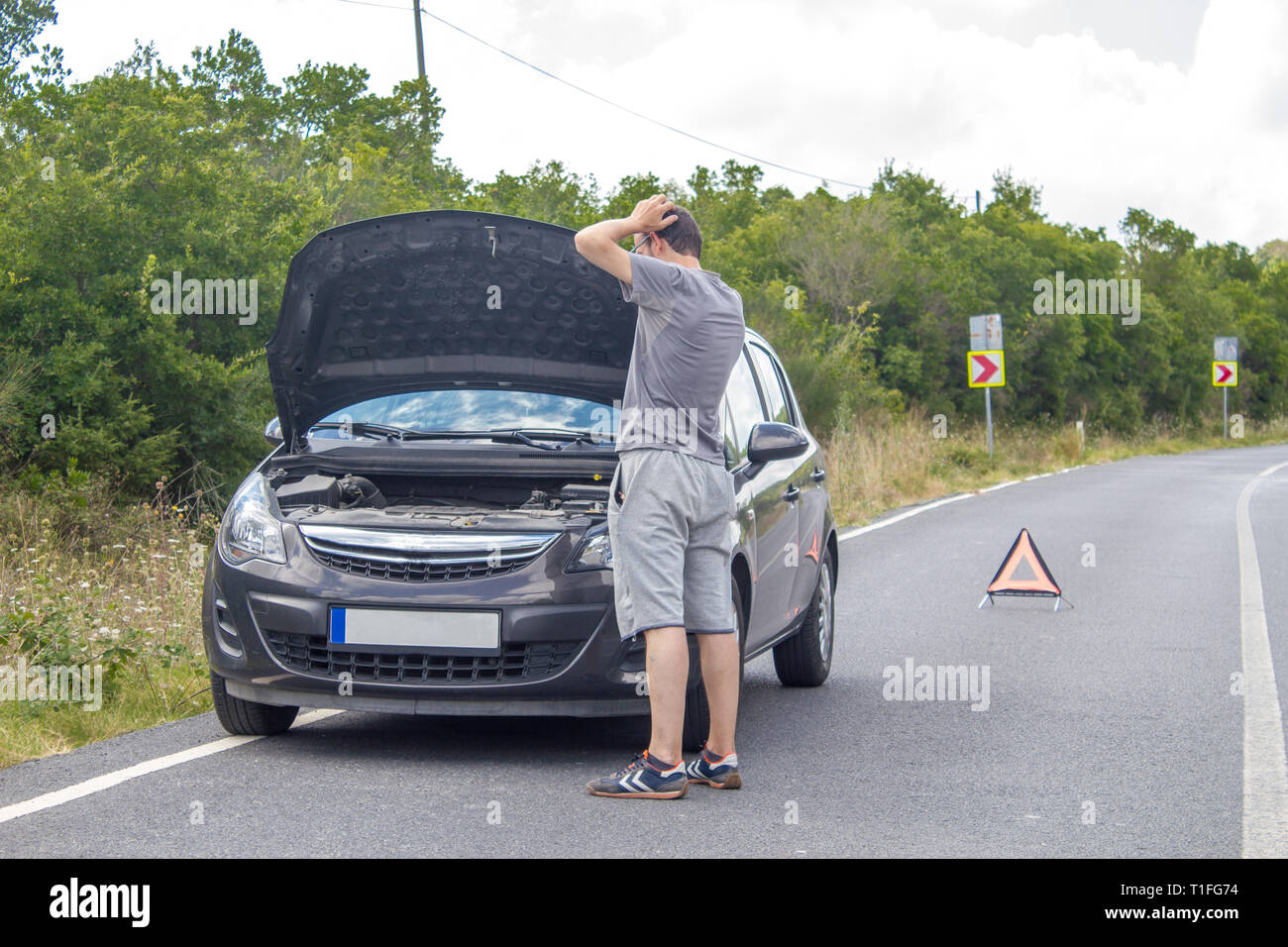 Location de dysfonctionnement sur la campagne. Location en attente de l'aide sur la route. Panne de voiture. Homme avec panne de voiture. En attente de l'assistance routière Banque D'Images
