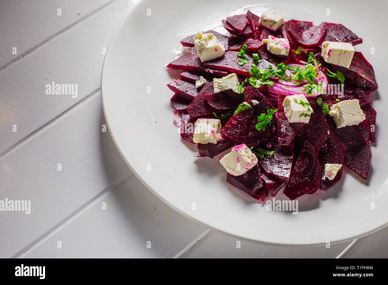 Salade de betteraves et de vitamine de la Feta dans une assiette blanche sur un fond de bois Banque D'Images