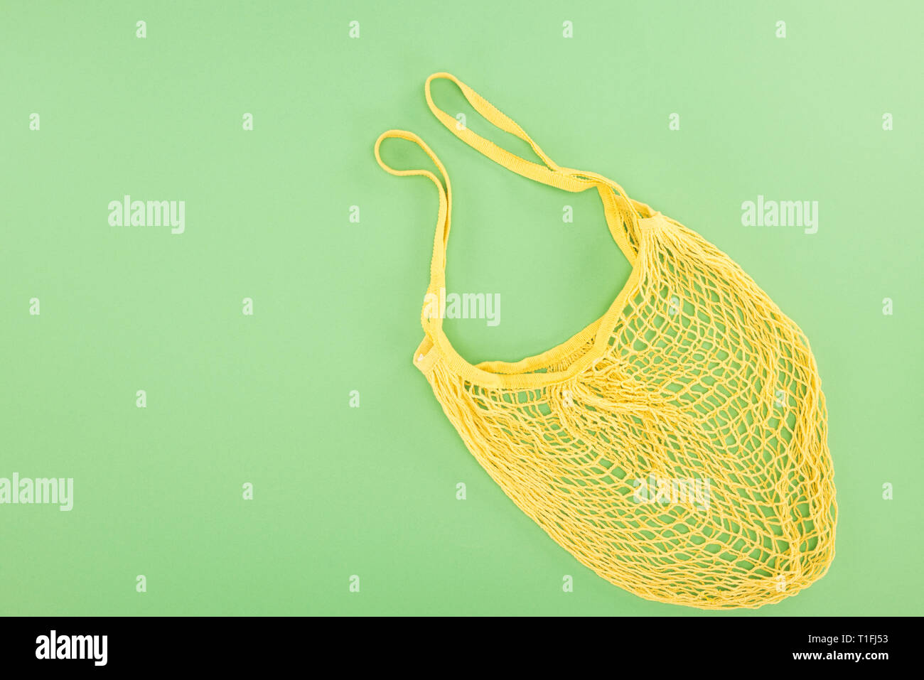 Vue de dessus du sac chaîne jaune sur fond vert clair Banque D'Images