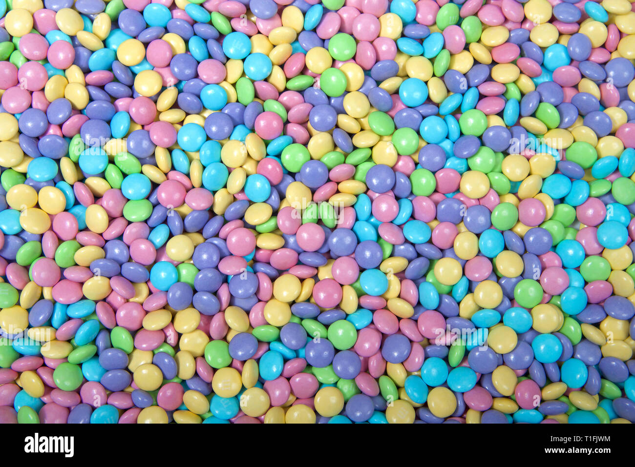Arrière-plan de chocolats enrobés de sucre dans des tons pastel, thème de Pâques Banque D'Images