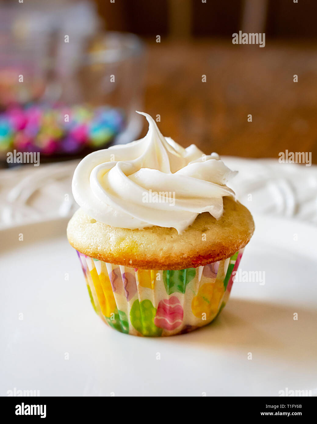 Frosted cupcake fraîchement mini sur une plaque blanche. Saupoudre de décoration à l'arrière-plan. Banque D'Images