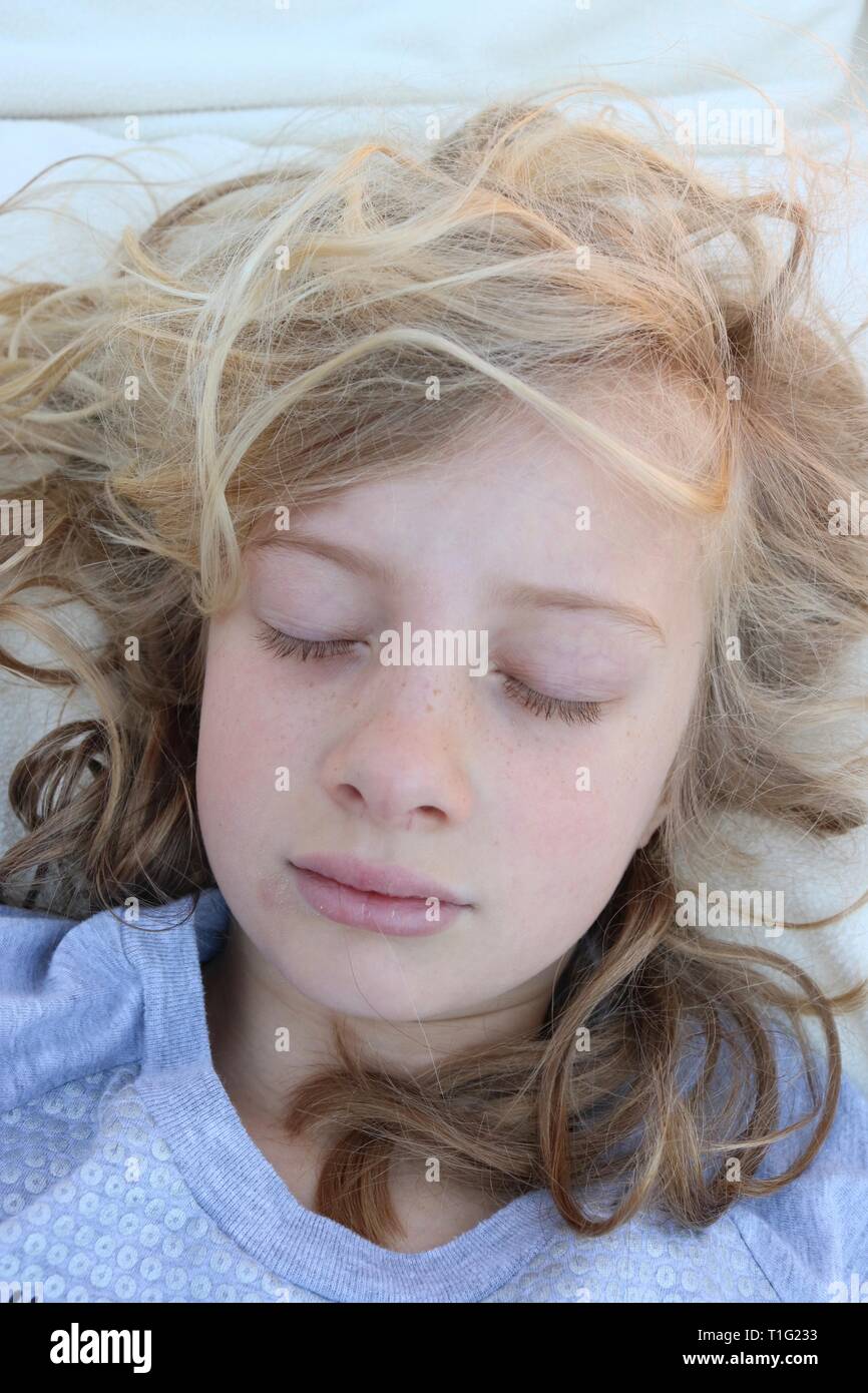 Portrait d'une jeune fille blonde curly dormir paisiblement Banque D'Images