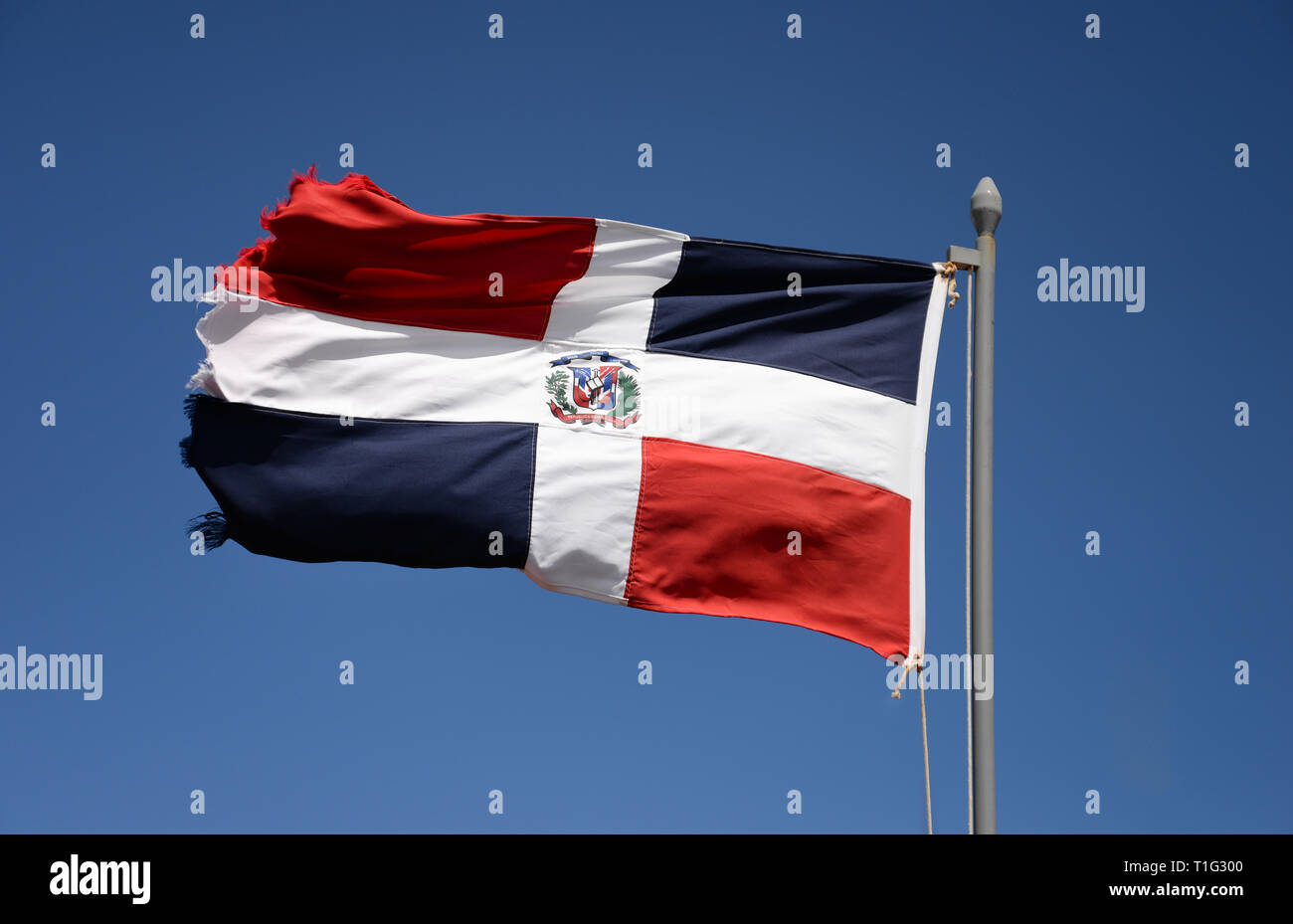 De brandir le drapeau de la République dominicaine contre le ciel bleu Banque D'Images