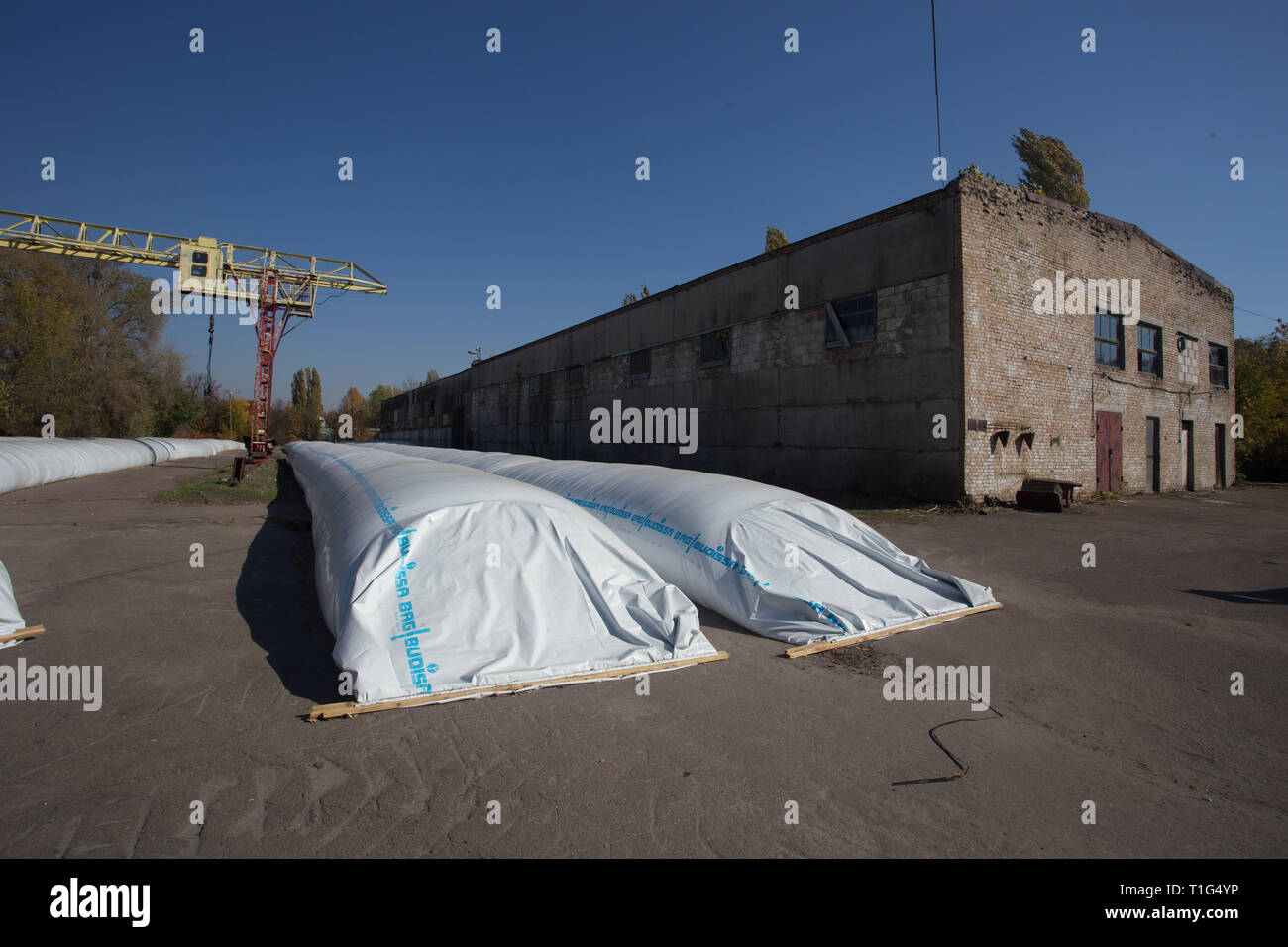 Le thème est l'industrie et agraire. La moisson est stocké dans de grands, imperméables, étanches sacs blancs à l'air libre à l'extérieur de la ferme. Banque D'Images