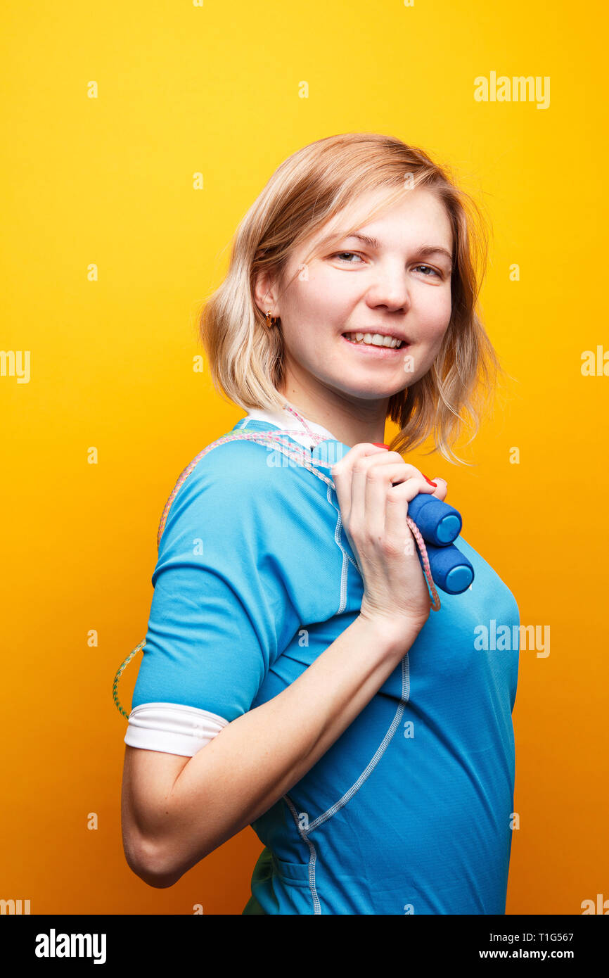 Photo de sport femme avec corde à vide sur fond orange. Banque D'Images