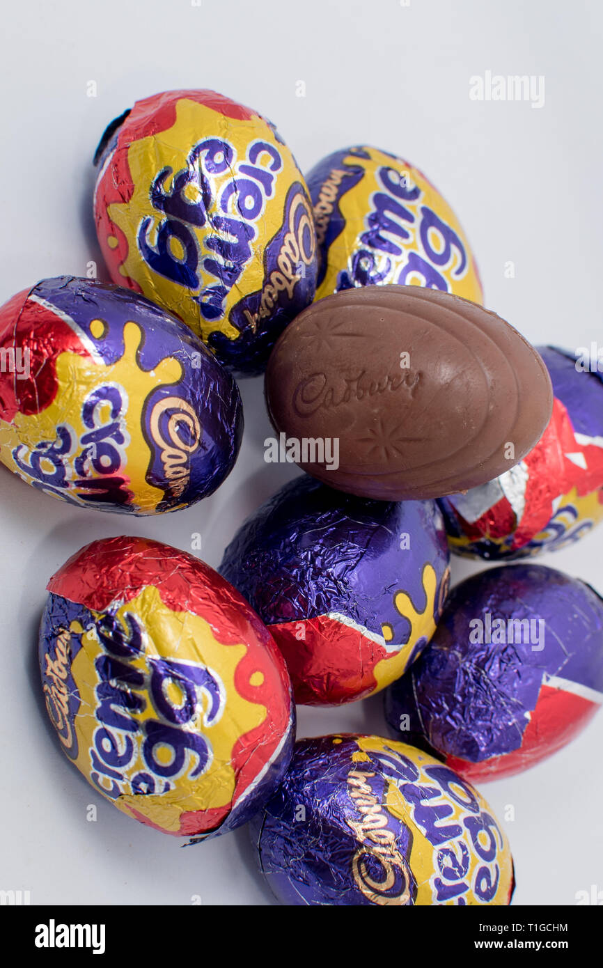 Londres, UK - Mars 2019 : Cadbury creme egg dans différentes tailles dans un emballage coloré montrant un chocolat emballé avec remplissage intérieur blanc et jaune Banque D'Images