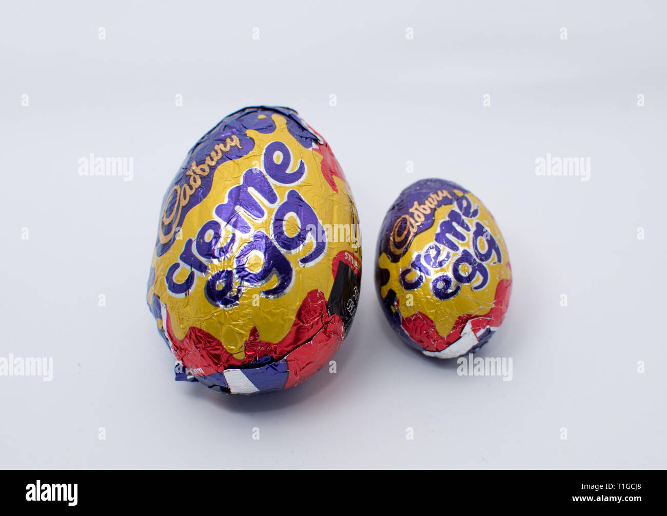 Œuf de crème Cadbury de différentes tailles sur fond blanc Banque D'Images