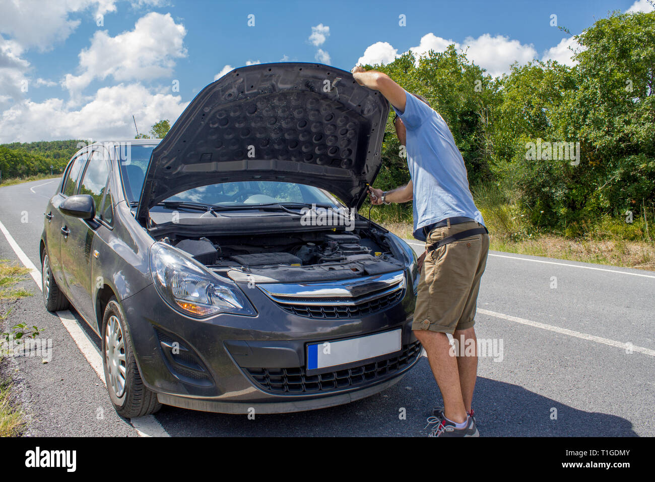Location de dysfonctionnement sur la campagne. Panne de voiture. Homme avec panne de voiture. L'homme contrôle du moteur de voiture Banque D'Images
