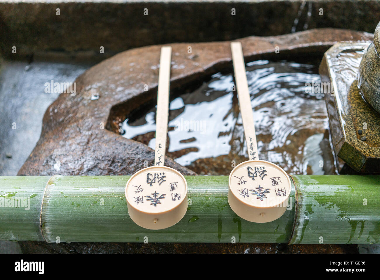 Un seau en bois rempli d'eau pour que les visiteurs se lavent les mains et boivent de l'eau dans un temple japonais à Kyoto, au Japon Banque D'Images