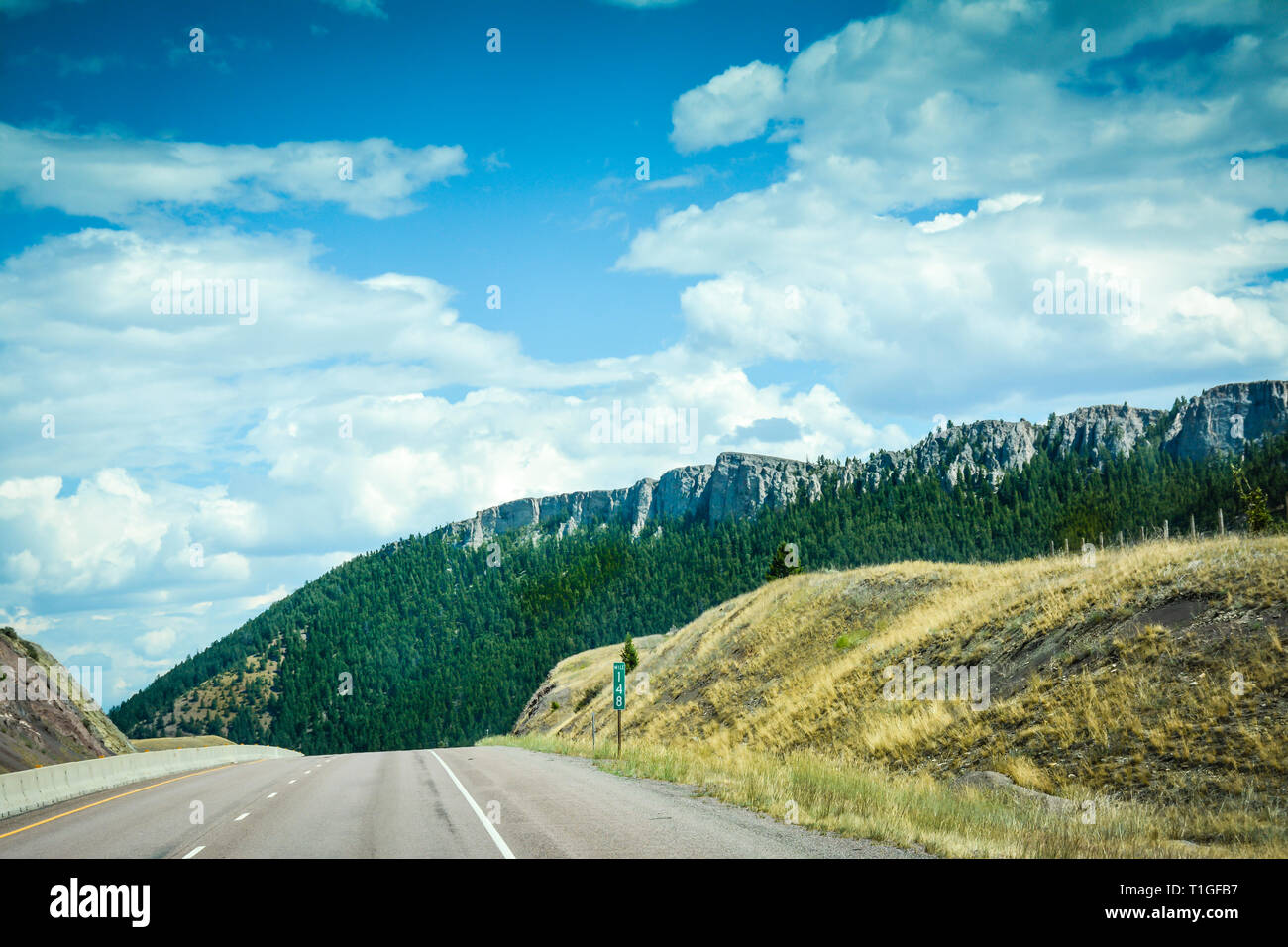 Vue depuis l'autoroute I-90 de l'approche d'une direction de descente à travers les montagnes de Big Sky Country, l'ouest du Montana, USA Banque D'Images