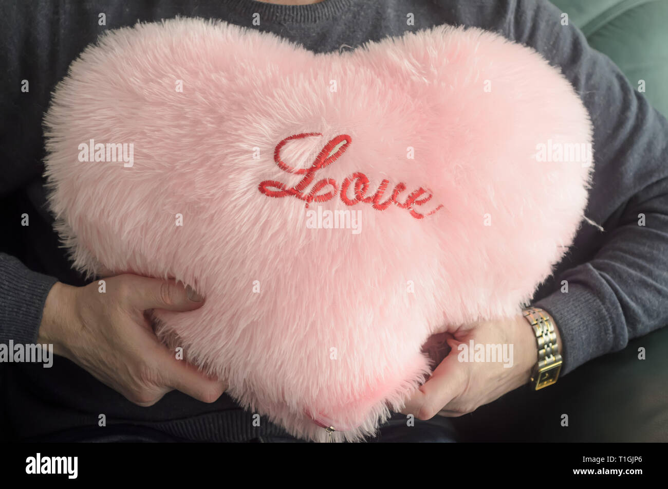 Un homme est titulaire d'un oreiller en forme de cœur avec l'amour de  l'inscription dans les mains .Concept de la Saint-Valentin Photo Stock -  Alamy