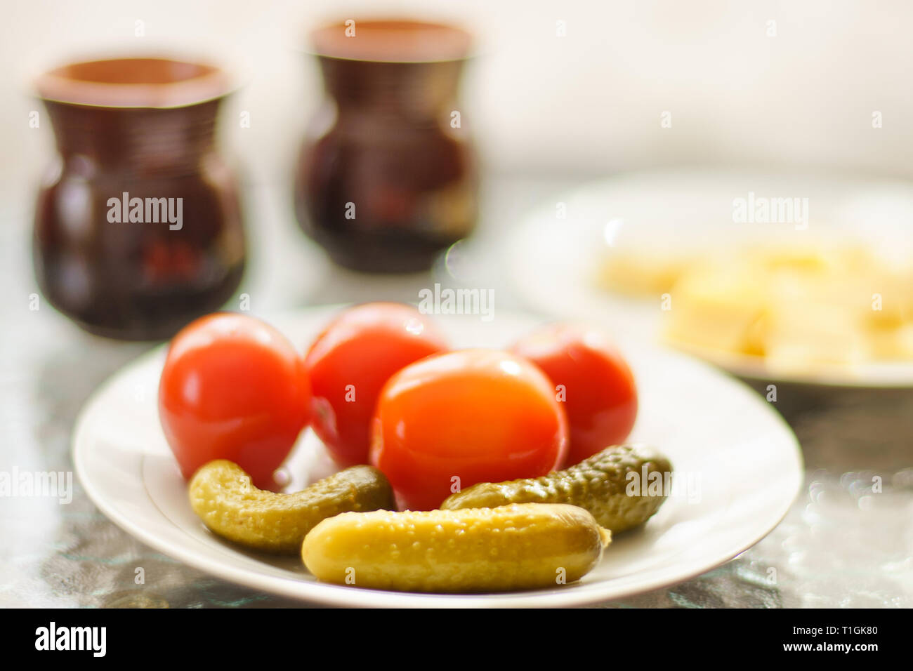 Concombres et tomates sur une table avec deux tasses Banque D'Images