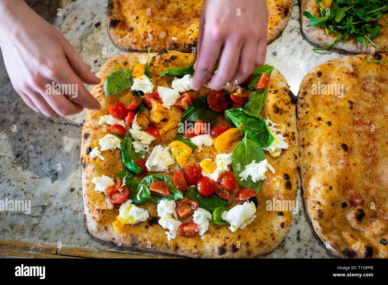Les mains de l'homme faire de la préparation d'un roman style italien pizza dans une pizzeria/trattoria Banque D'Images