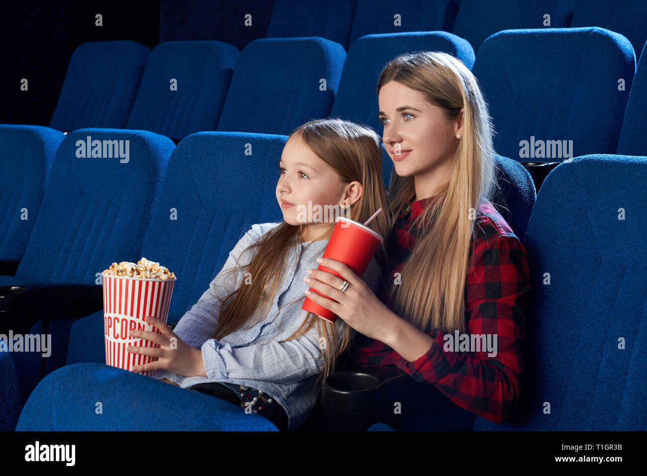 Un Enfant Regarde Un Film Avec Du Pop-corn Devant Une Lumière