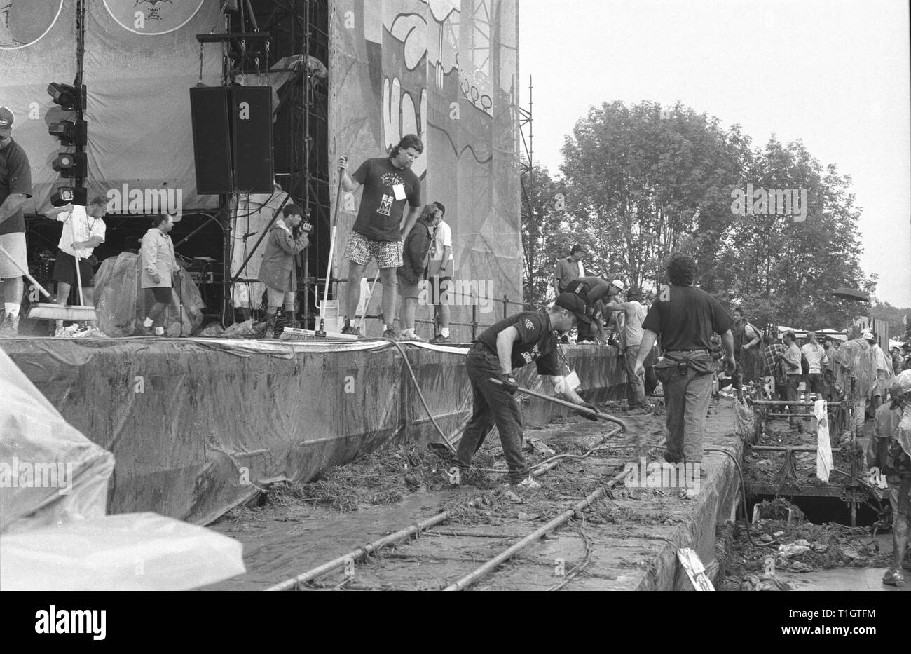 Les travailleurs ont montré l'étape de raclage et pelleter de la boue et de l'herbe au loin de la vidéo rail track à Woodstock 94 à Saugerties, New York. Banque D'Images
