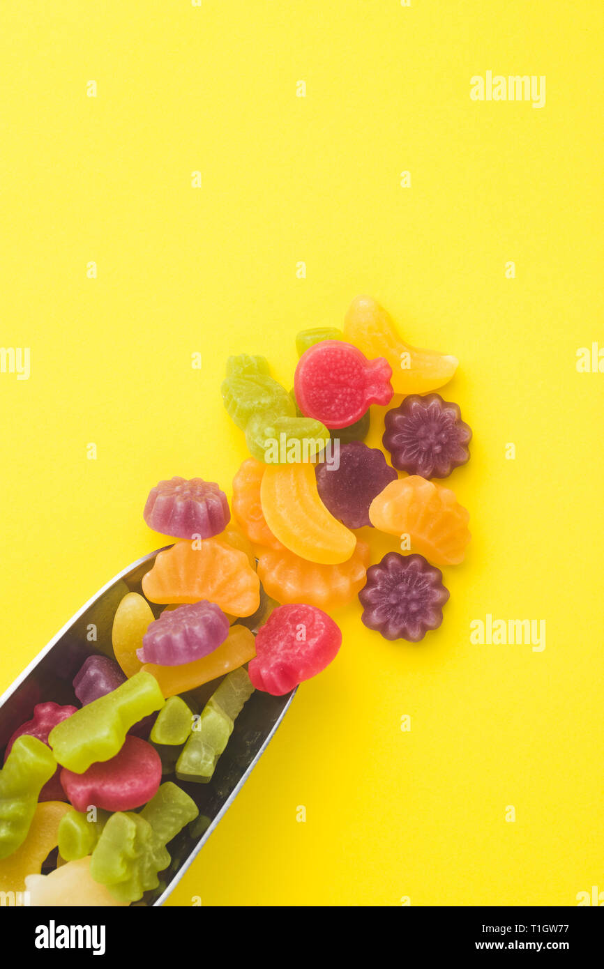 Fruit jelly bonbons dans scoop sur fond coloré. Banque D'Images