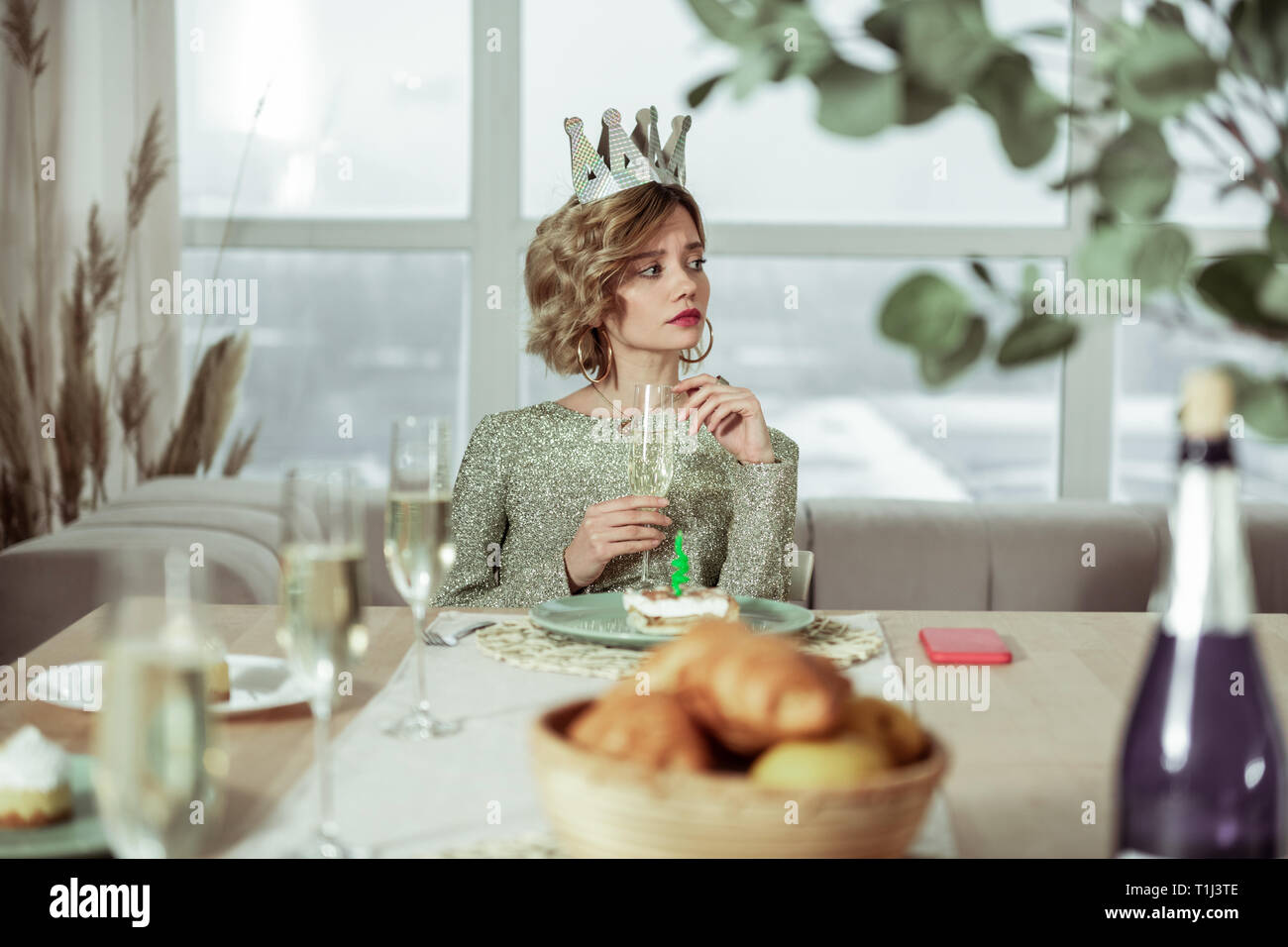 Femme aux cheveux courts bouclés cut drinking champagne sur son propre Banque D'Images