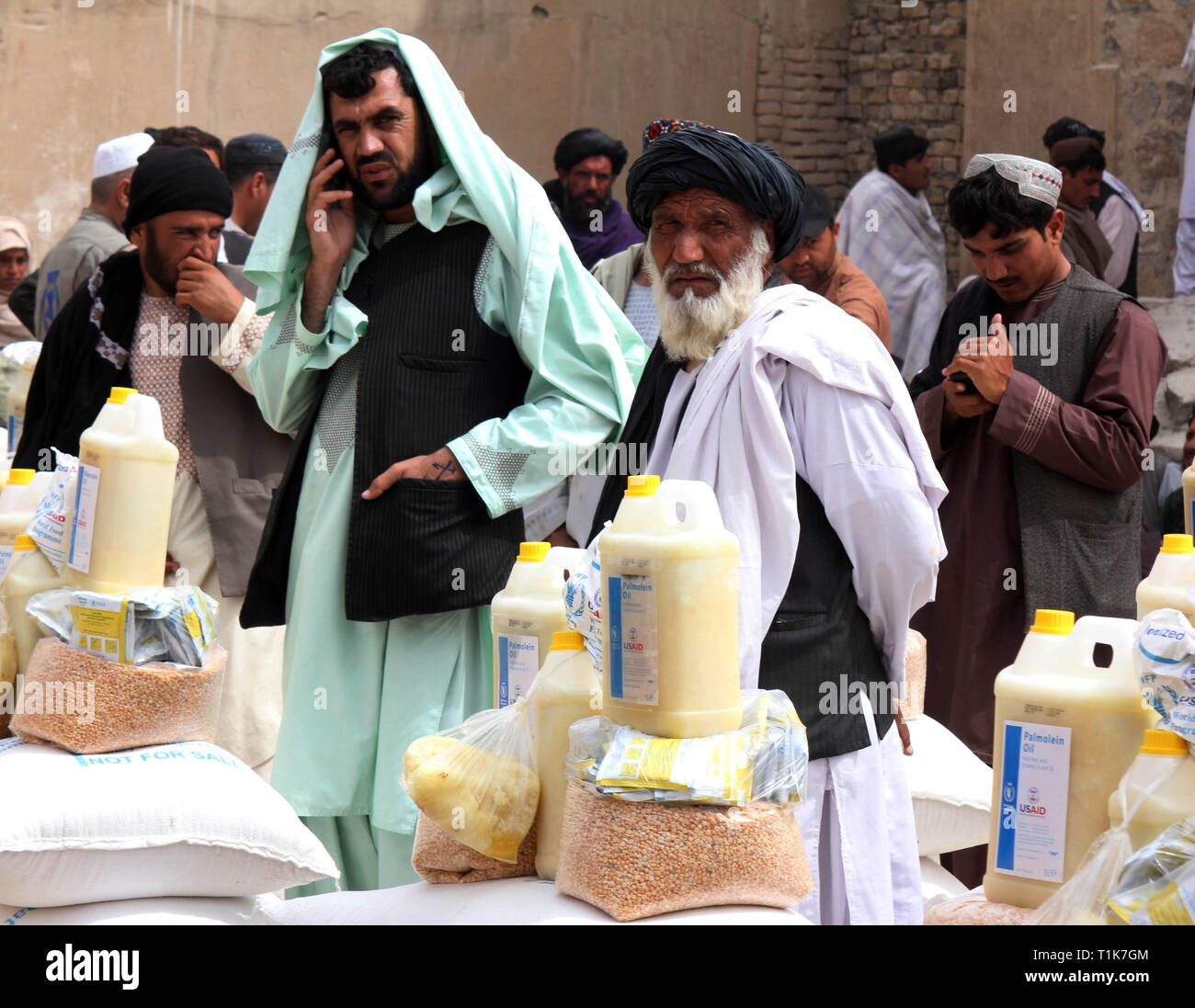 Kandahar, Afghanistan. Mar 27, 2019. Les gens reçoivent des secours en cas de marchandises dans la province de Kandahar, au sud de l'Afghanistan, le 27 mars 2019. Plus de 10 000 ménages ont été déplacées suite aux dernières fortes inondations dans le sud de l'Afghanistan et les provinces de l'ouest, le Bureau des Nations Unies pour la coordination des affaires humanitaires (OCHA) a signalé récemment. Sanaullah Crédit : Seaim/Xinhua/Alamy Live News Banque D'Images