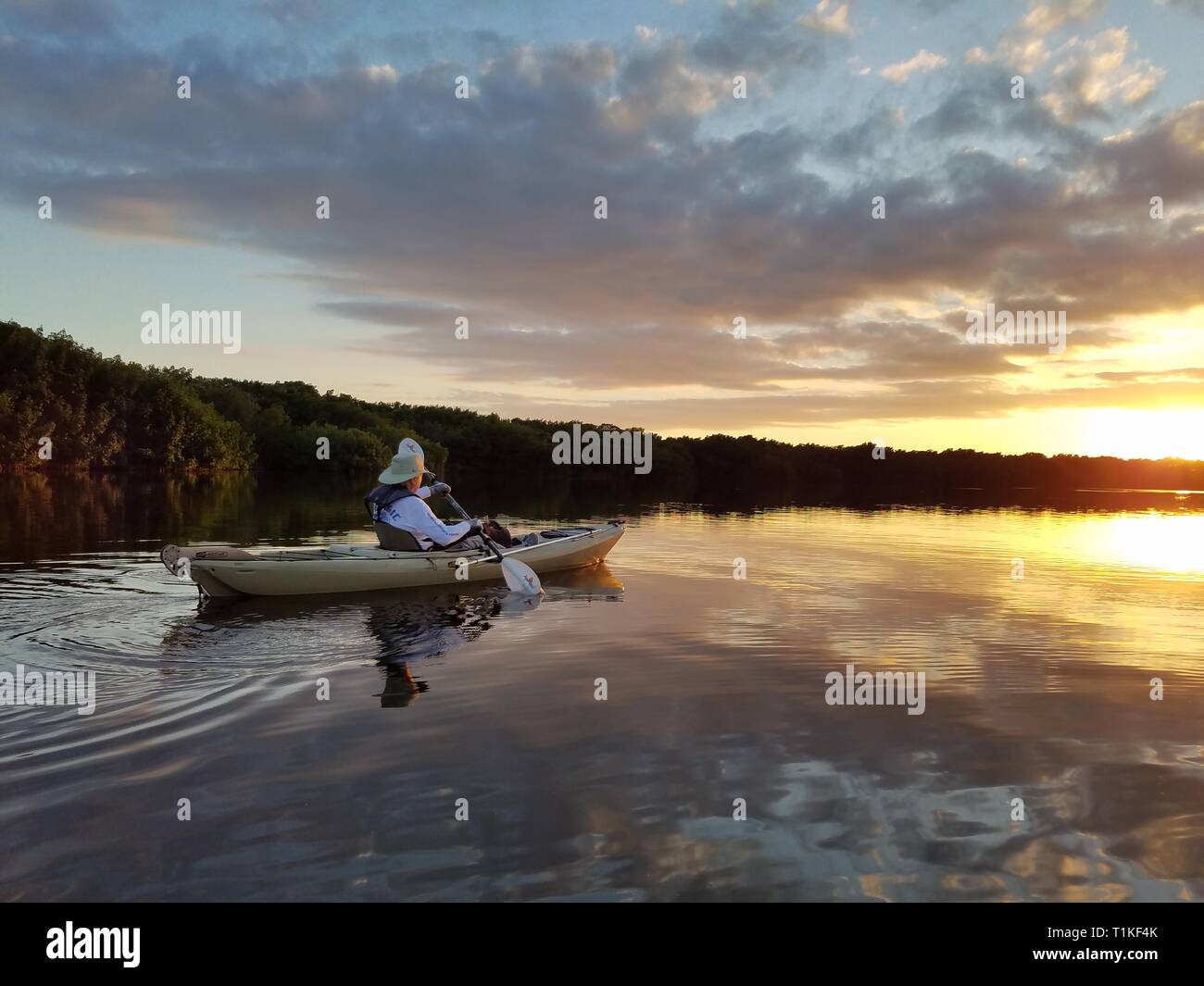 Le Parc National des Everglades, Floride 02-05-2017 senior kayaks sur une calme au milieu de la baie exceptionnellement Foulque frappant réflexions cloud. Banque D'Images