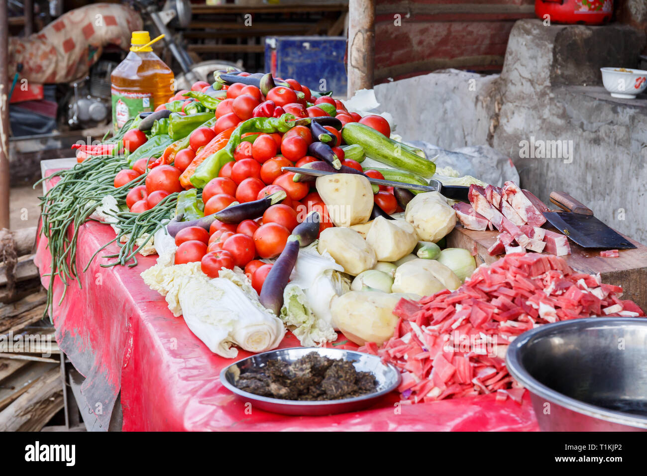 Stand avec des légumes sur l'affichage pour la vente à Kashgar Marché des animaux. Y compris les tomates, aubergines, haricots verts et poivron vert. Produits locaux. Banque D'Images