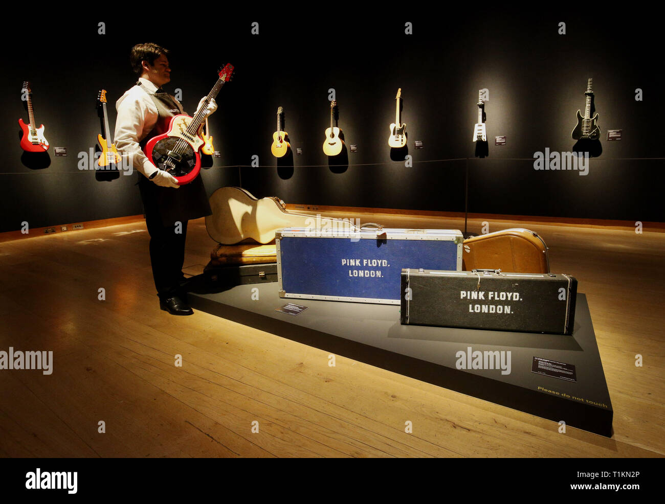 Un manutentionnaire berceaux un résonateur électrique National 1991 Solid-Body R-1 guitare lors d'un aperçu de l'exposition préalable à la vente de la collection de guitare personnels de Pink Floyd David Gilmour, chez Christie's à Londres. Banque D'Images