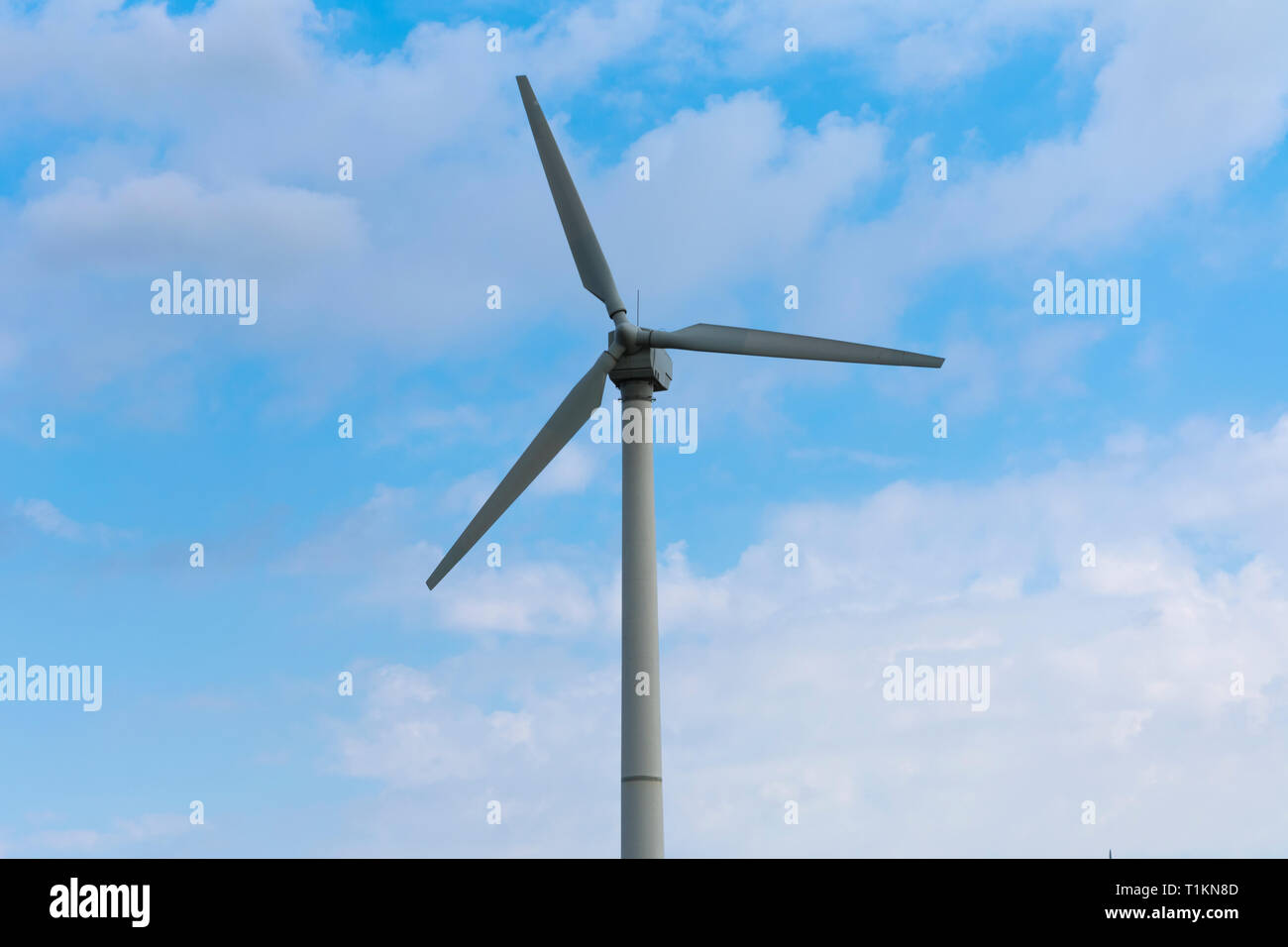 Wind turbine dans un fond de ciel bleu et nuages blancs Banque D'Images