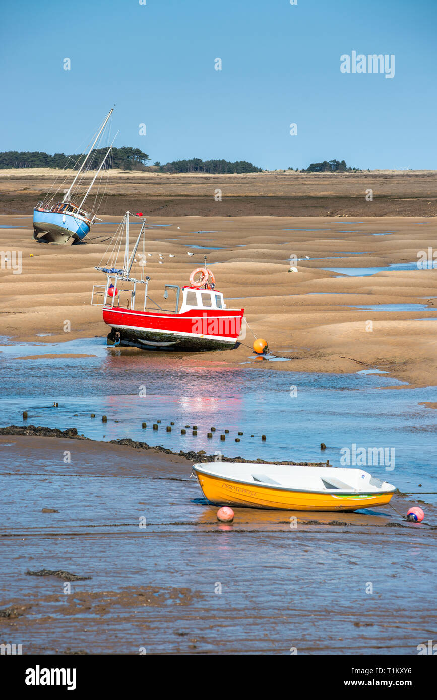 Bateaux colorés sur les bancs de sable à marée basse sur les marins de la flotte et de l'estuaire de la rivière au Wells next the sea, North Norfolk Coast, East Anglia, Angleterre, Royaume-Uni. Banque D'Images
