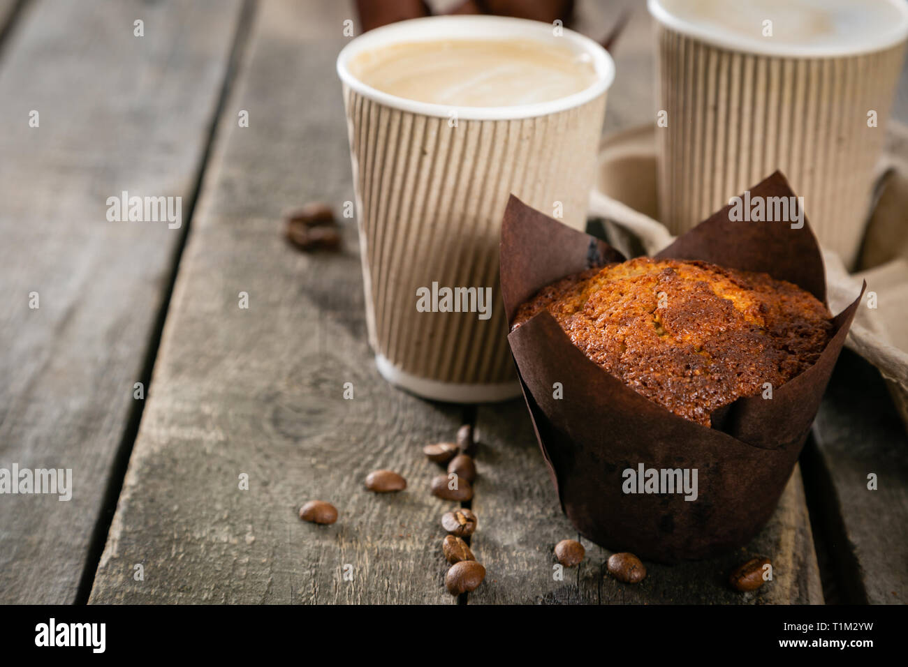 Café pour aller avec un muffin en fond de bois Banque D'Images