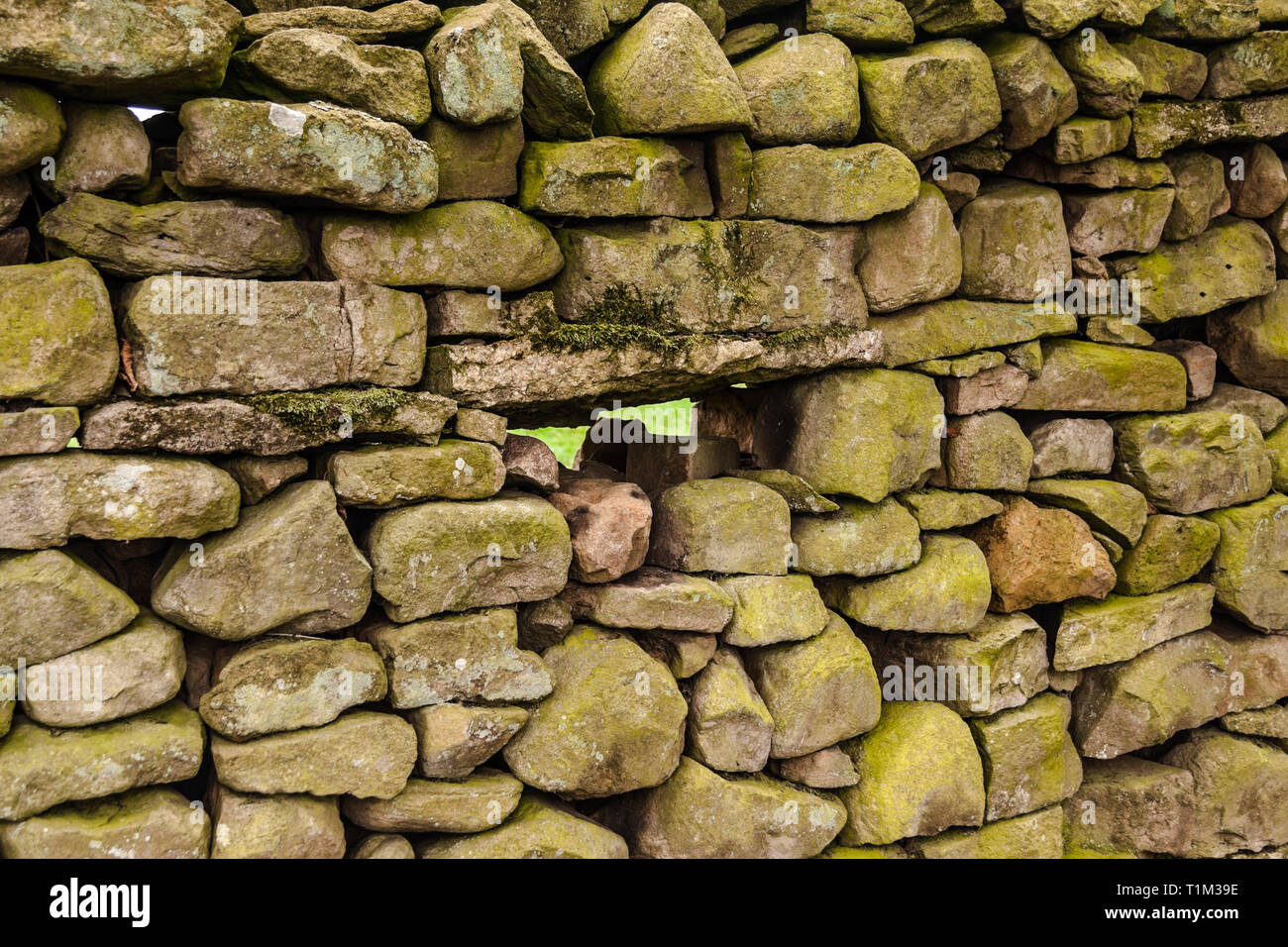 Un gros plan d'un mur en pierre sèche à Reeth, North Yorkshire, Angleterre, Royaume-Uni, avec un espace au milieu du mur Banque D'Images