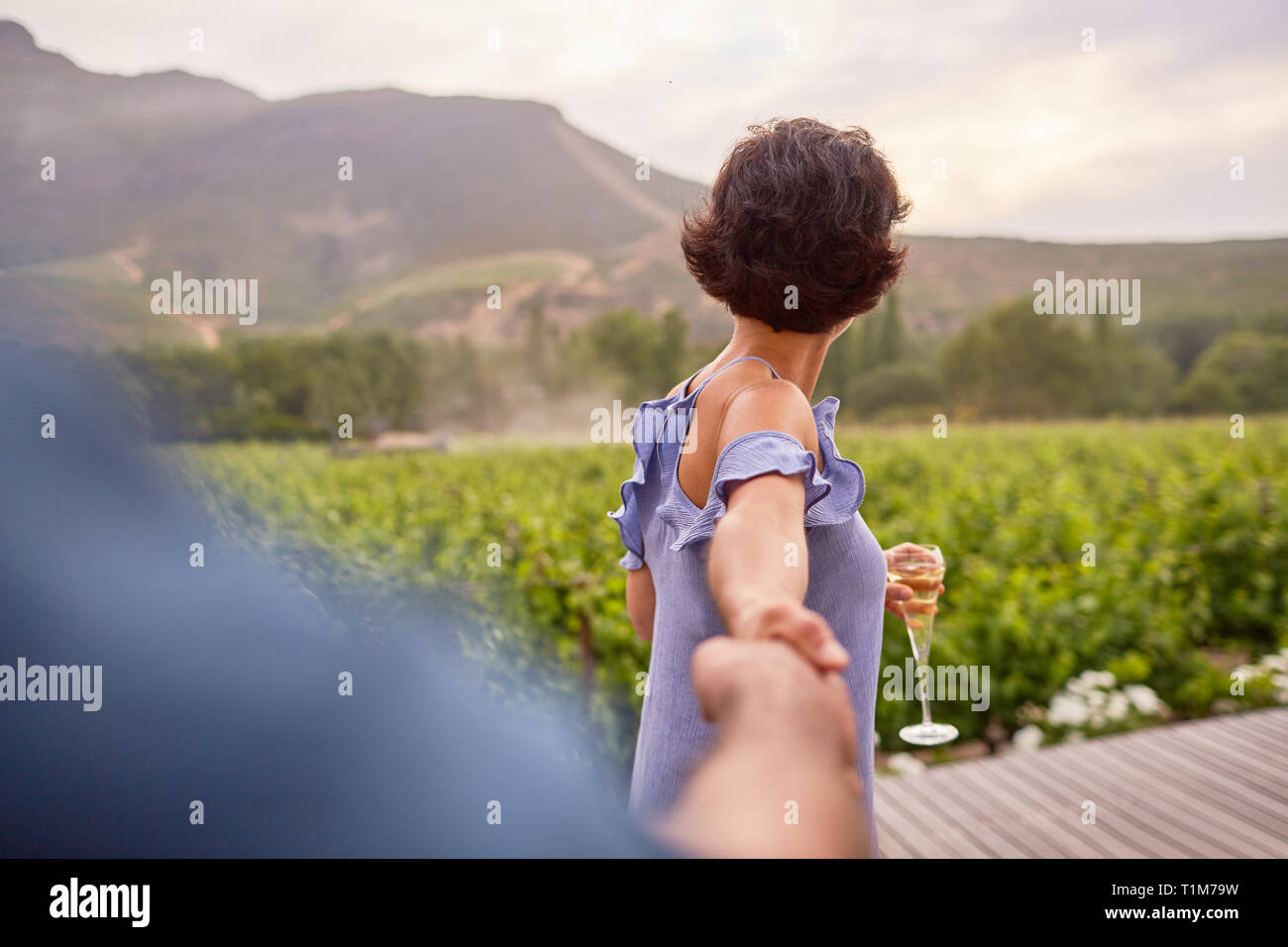 Couple avec champagne holding hands on patio Banque D'Images