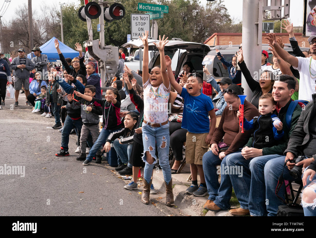 Les enfants crient et vague de riders sur demande de flottement au cours de bibelots Washington's Birthday celebration annuel défilé en Laredo TX. Banque D'Images