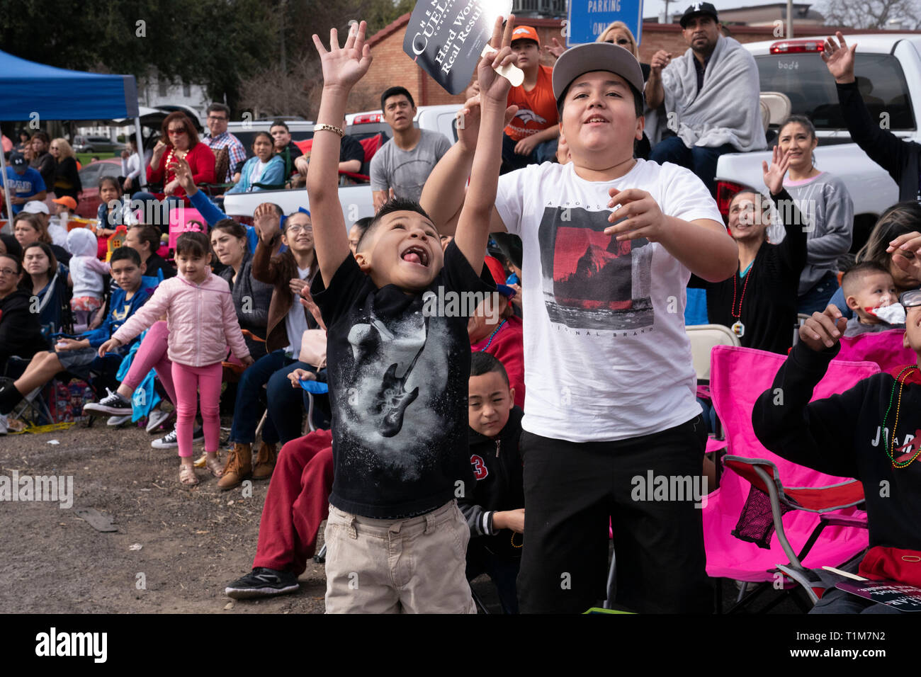 Les enfants crient et vague de riders sur demande de flottement au cours de bibelots Washington's Birthday celebration annuel défilé en Laredo TX. Banque D'Images