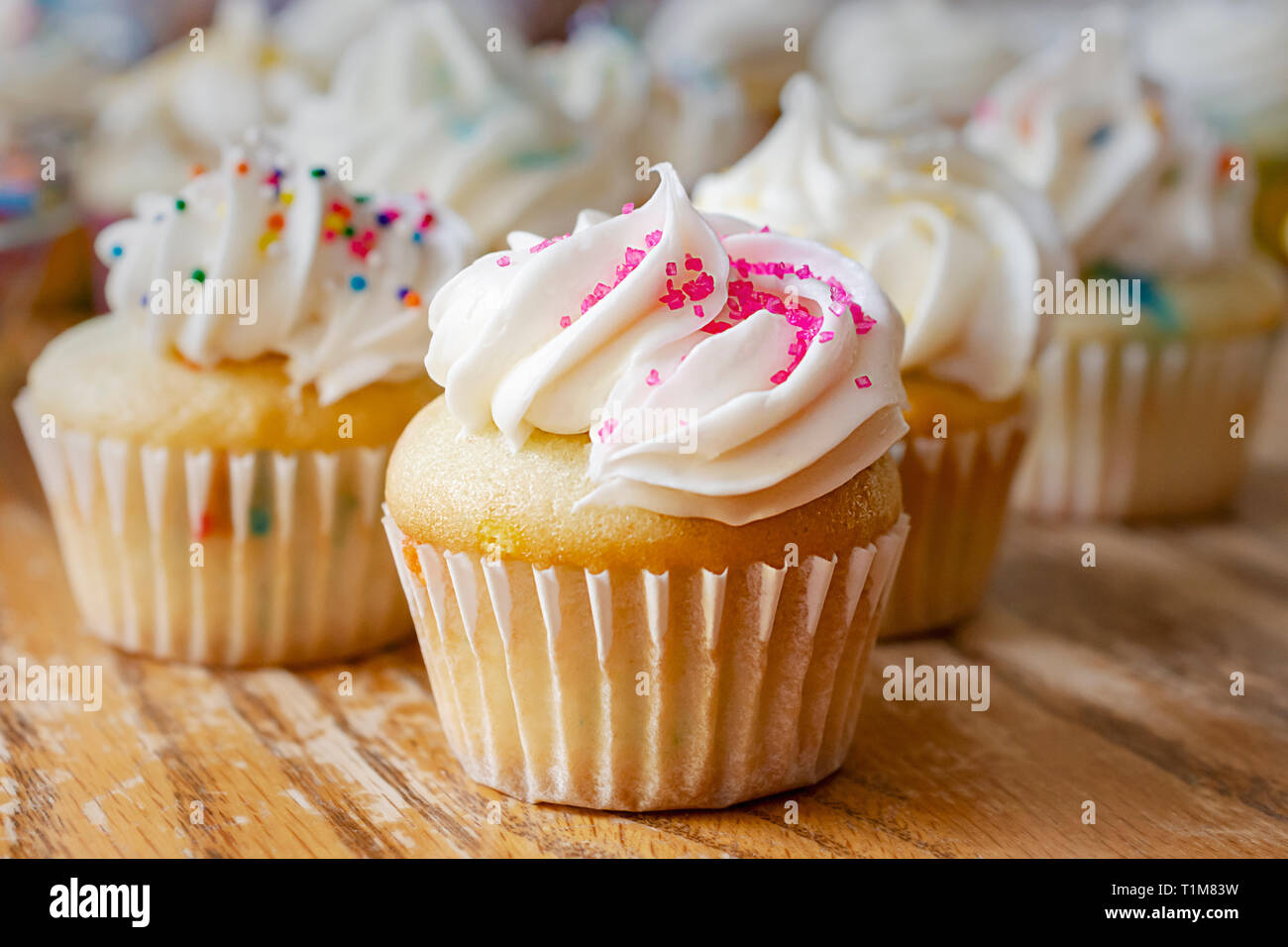 Mini cupcakes décorés de printemps et de Pâques candy sprinkles. Cupcakes supplémentaires à l'arrière-plan flou. Banque D'Images