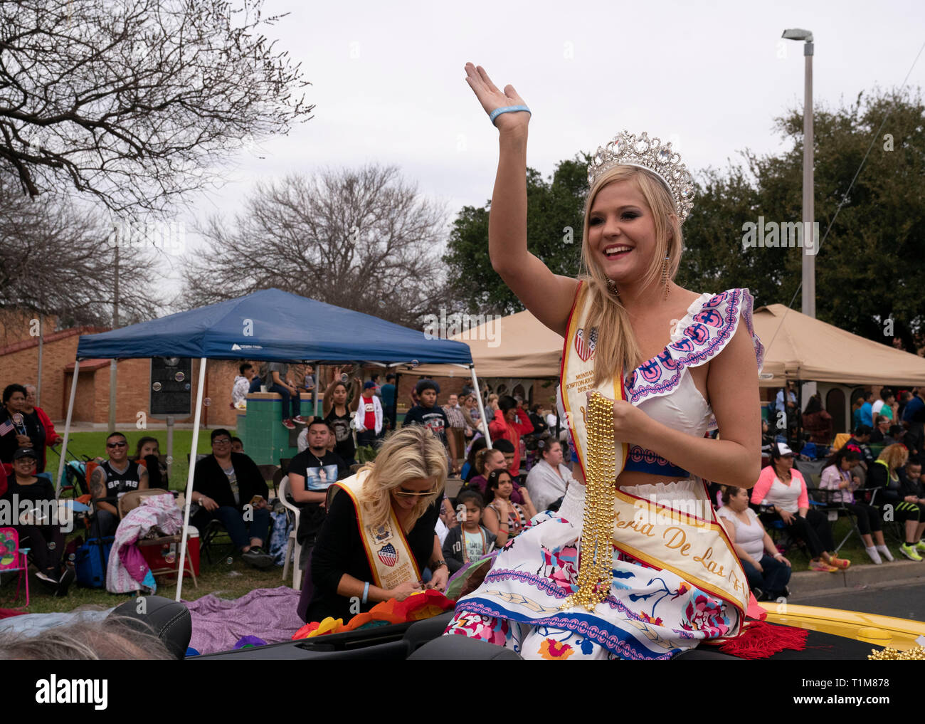 Young woman wearing crown se trouve à l'arrière de la voiture décapotable et les vagues de foule pendant l''année de l'Anniversaire de Washington parade en Laredo TX USA Banque D'Images