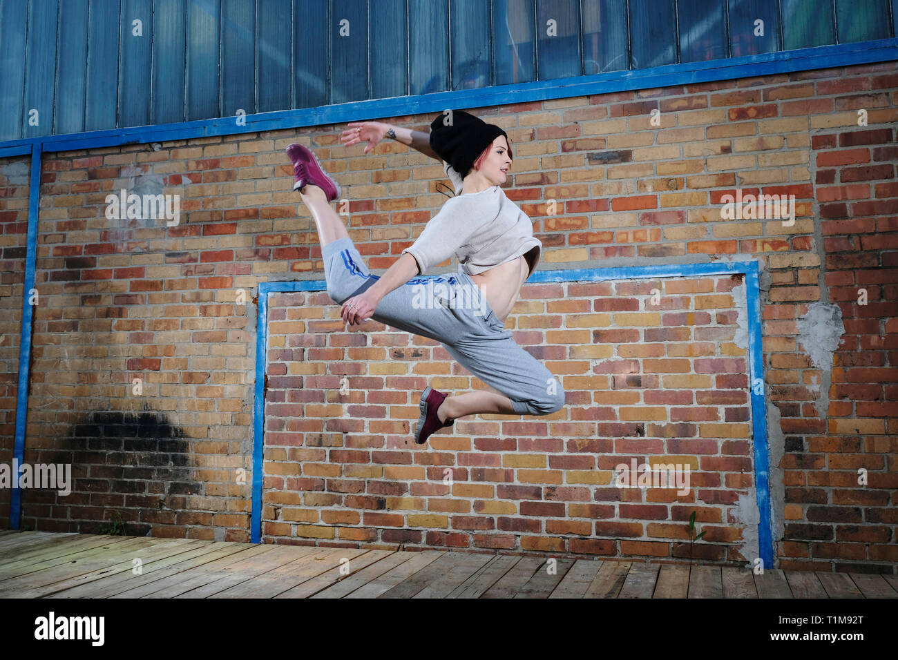 Femme danseuse moderne l'exécution contre brick wall Banque D'Images