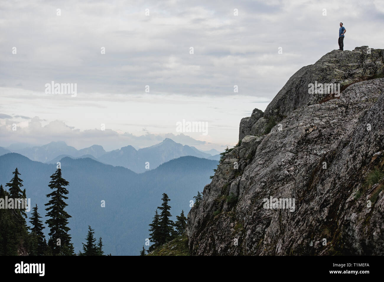 Male hiker debout sur des montagnes escarpées, à la vue, à la montagne de chien, BC, Canada Banque D'Images