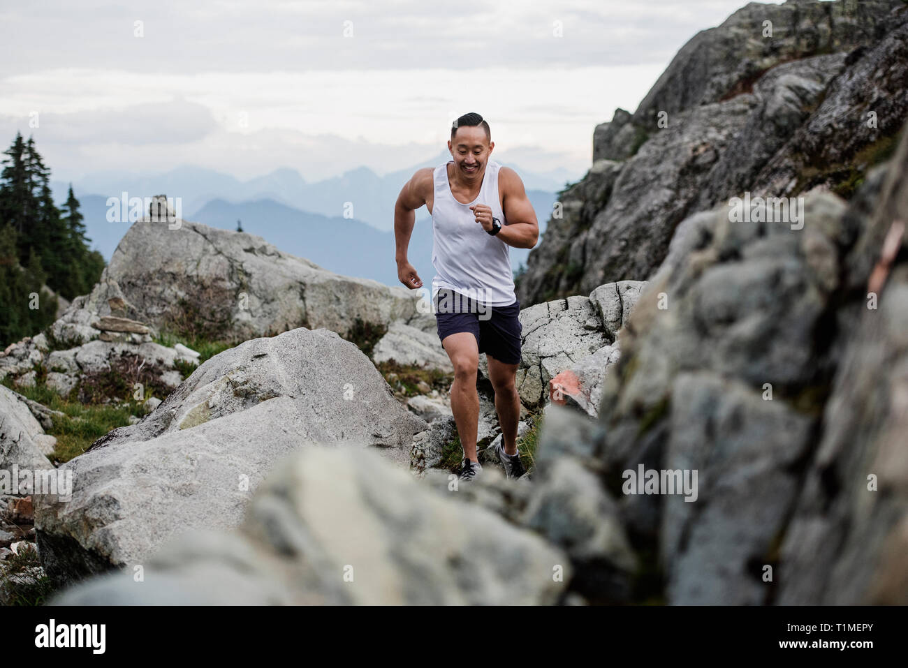 Male hiker fonctionnant sur des rochers, le chien Mountain, BC, Canada Banque D'Images