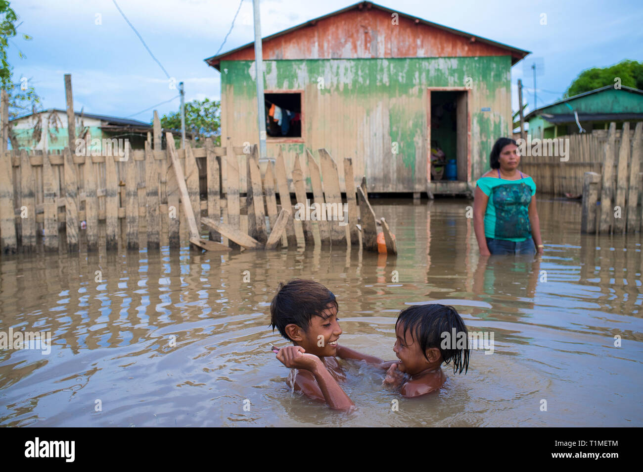 2015 Inondations en Amazonie brésilienne - les enfants jouent dans les eaux de la rivière acre de terre à Taquari, district de la ville de Rio Branco, l'état d'Acre. Les inondations ont touché des milliers de personnes dans l'Etat d'Acre, dans le nord du Brésil, depuis le 23 février 2015, lorsque certaines des rivières de l'état, en particulier l'Acre, la rivière a débordé. De plus fortes précipitations a forcé les niveaux de la rivière plus haut encore, et le 03 mars 2015, le gouvernement fédéral du Brésil a déclaré l'état d'urgence dans l'état d'Acre, où les conditions d'inondations situation a été décrite comme la pire en 132 ans. Banque D'Images