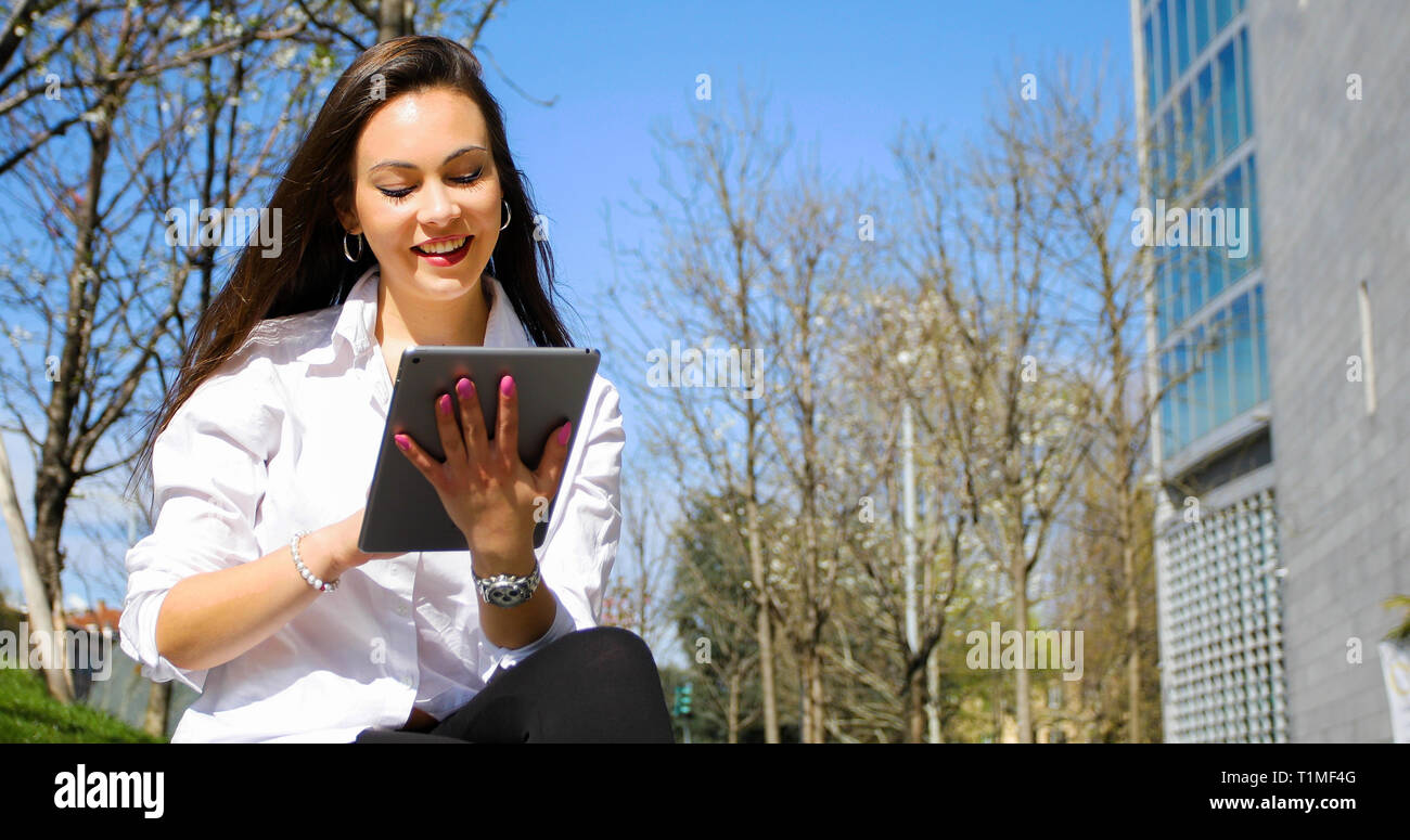 Smiling businesswoman using a digital tablet outdoor Banque D'Images
