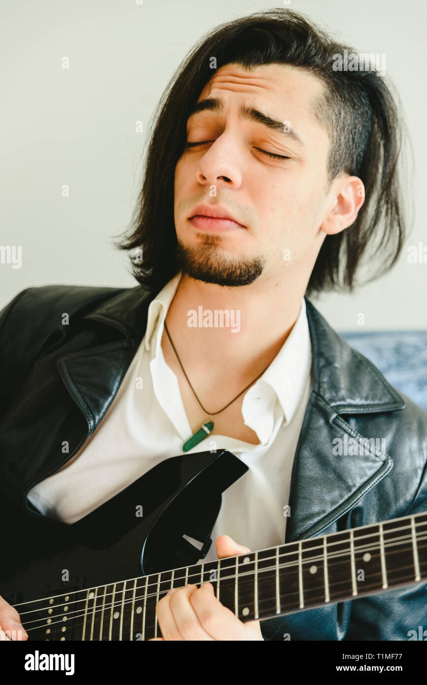 Jeune guitariste d'Amérique latine avec l'expression de concentration lors de  la lecture d'un morceau de rock Photo Stock - Alamy