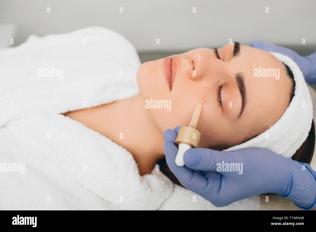 L'application de sérum de beauté visage féminin. Traitement sérum peau Banque D'Images