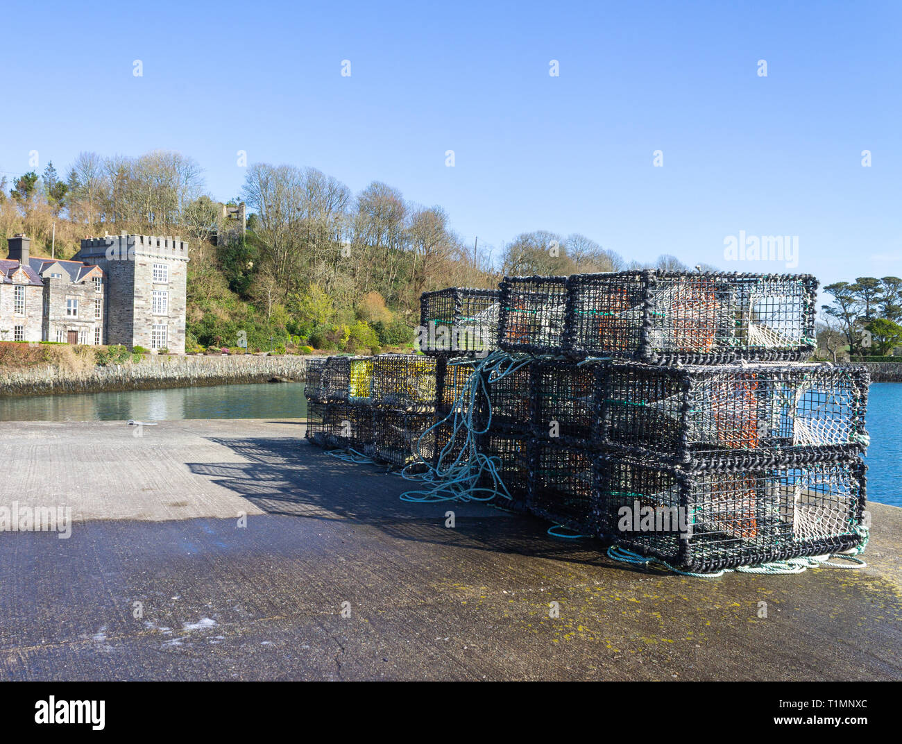 Des casiers à homard sur un quai avec un château en arrière-plan, castletownshend, West Cork, Irlande Banque D'Images