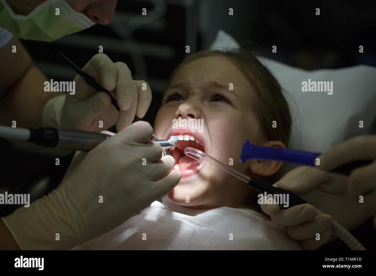 Peur petite fille à l'office, les dentistes dans la douleur lors d'un traitement. Les soins dentaires pédiatriques et la peur du dentiste concept. Banque D'Images